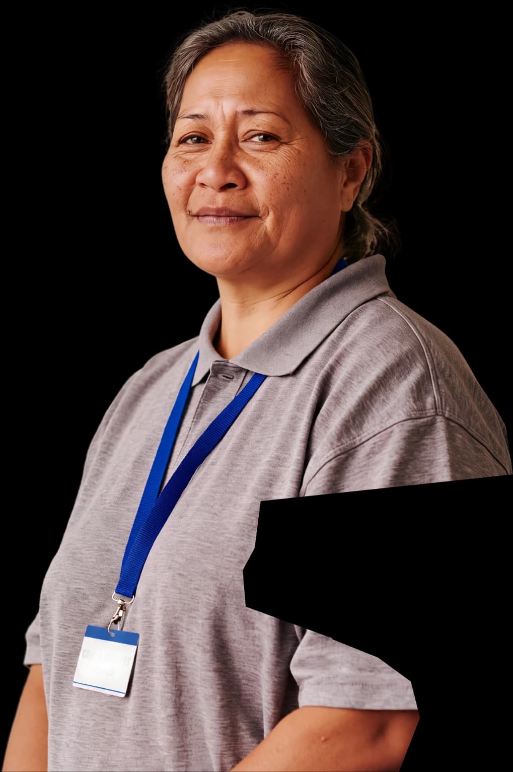 A care and support worker in a grey polo wearing a lanyard and ID badge